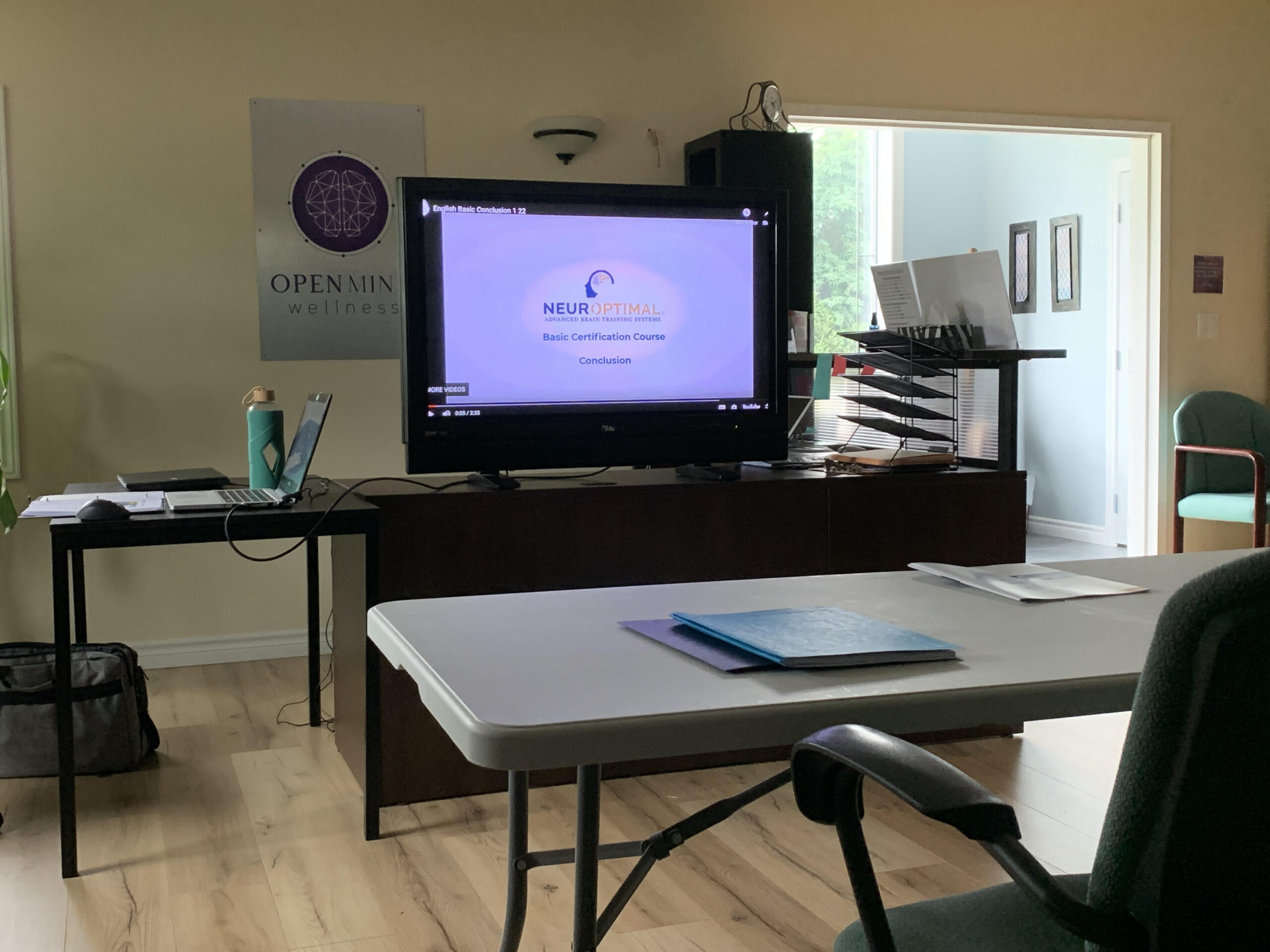 Screen displaying a NeurOptimal basic certification course presentation in a classroom setting