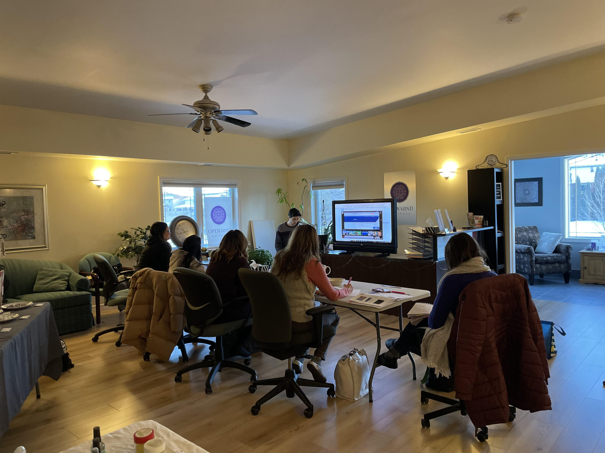 Small group seated at tables attending a neurofeedback training session at Open Mind Wellness